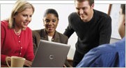 Group of people gathering around a computer